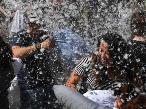 Feathers fly as participants attack each other with pillows during an International Pillow Fight Day event at Pershing Square in Los Angeles, California on April 1, 2017.  / AFP PHOTO / Mark RALSTONMARK RALSTON/AFP/Getty Images